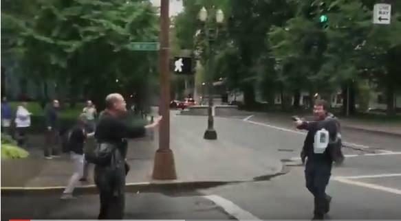 Malcolm Chaddock (L) tries to calm down gunman at Black Lives Matter rally in Portland, Oregon